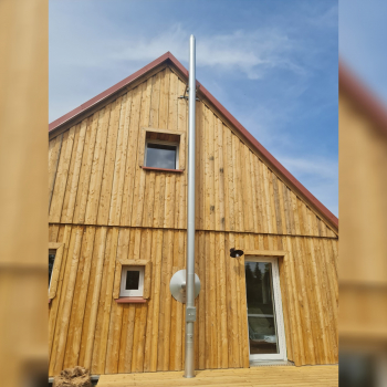 Kaminrohr Edelstahl vor Holzfasssade